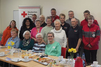 Viele Menschen sitzen und stehen für ein gemeinsames Fotos.