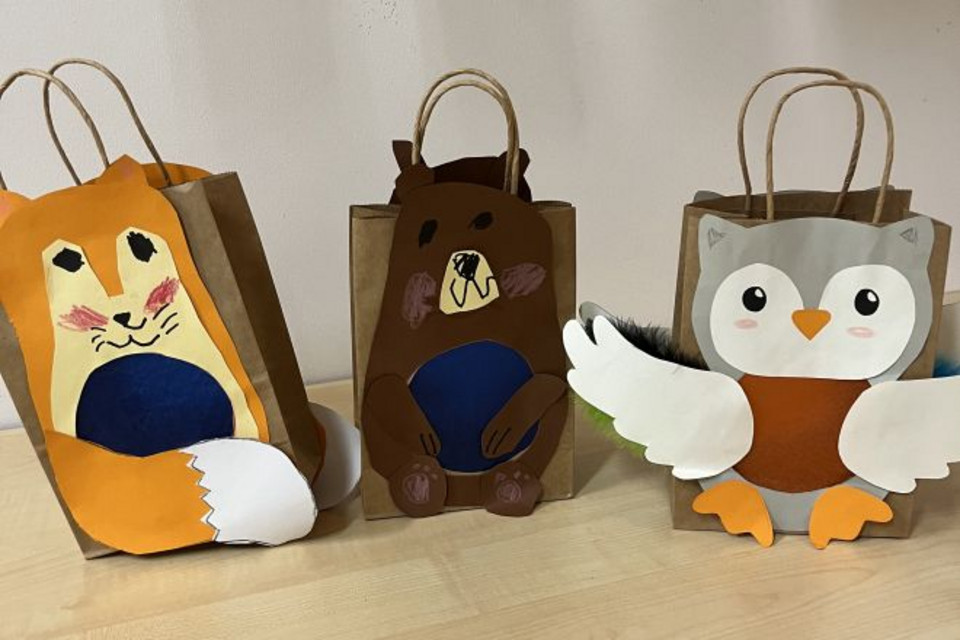 Drei selbstgebastelte Laternen stehen auf einem Tisch. Es handelt sich um die Motive Fuchs, Bär und Eule.